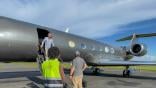 man exiting an aircraft while two other men look on